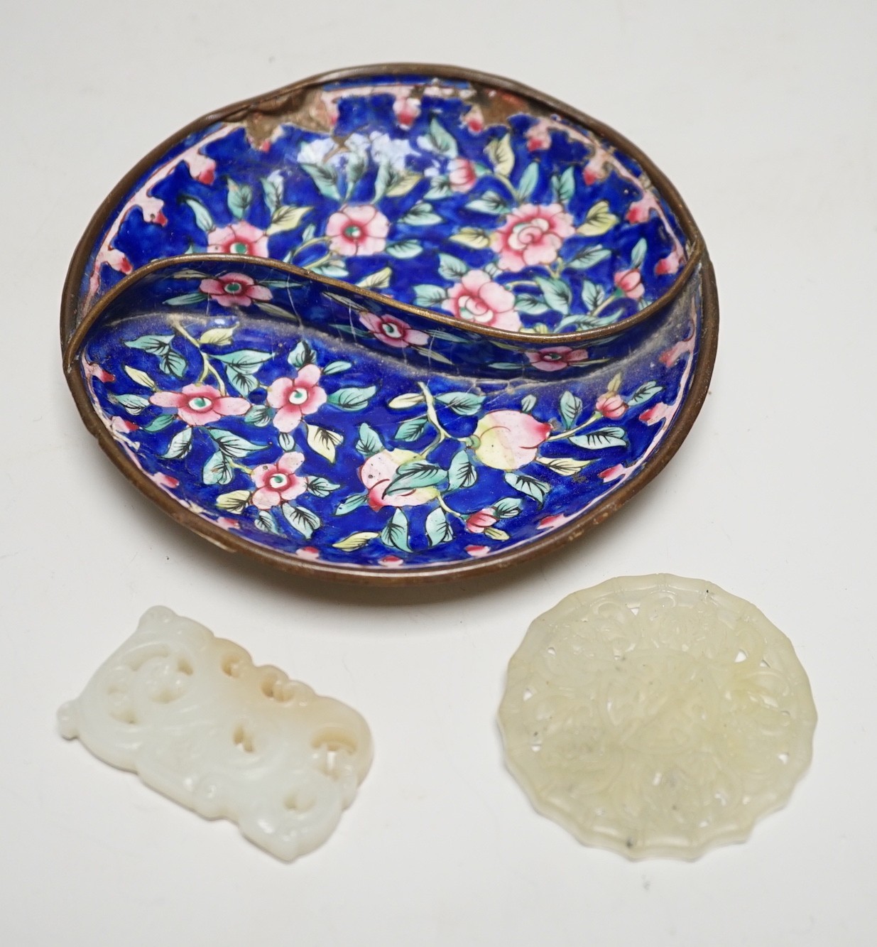 A Chinese pale celadon jade pendant, 4.6cm, a bowenite jade disc and a Canton enamel dish